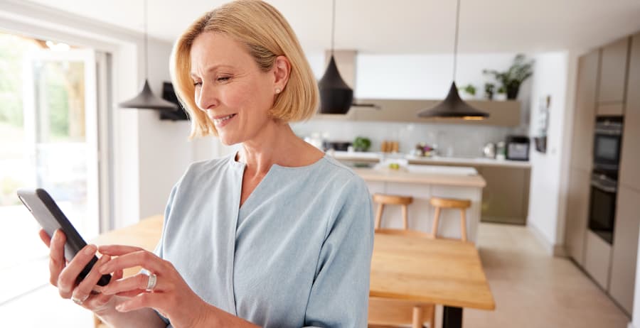 Homeowner holding a smartphone in a stylish home